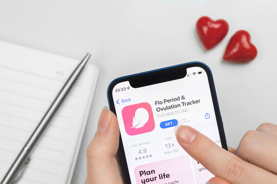 Flo Period and Ovulation tracker app icon close-up. Woman uses the application on Apple iPhone 12