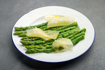 Asparagus grill on plate with parmesan on grey concrete table