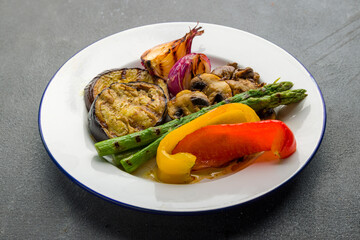 grilled vegetables on a plate on grey concrete table