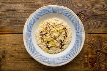 risotto four cheeses on plate on wooden table top view