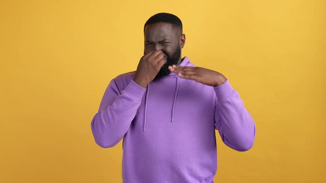 Guy close fingers nose diry stinky isolated vibrant color background