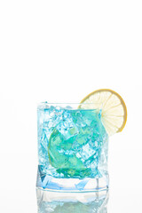 Fototapeta na wymiar Blue lagoon cocktail with blue curacao liqueur, vodka, lemon juice and soda, decorated with lemon slice