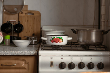 Pots on an old dirty gas stove. An old gas stove of the Soviet era in the kitchen