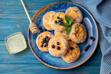 cheese pancake with cottage cheese blueberries on a blue plate for breakfast with honey and blueberries