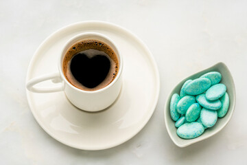 Turkish coffee with blue chocolate dragee on marble table
