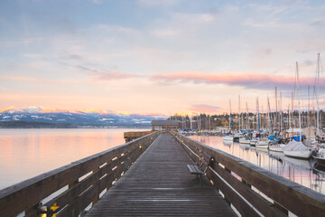 Sunset or sunrise at the waterfront boardwalk and marina on a cold winter day at Comox Harbour, British Columbia, Canada. - obrazy, fototapety, plakaty