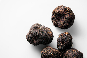 several freshly picked organic black truffles on a white background ready to serve in a restaurant....