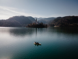 2 people doing sports, kayaking on lake bled in front of island bled in Slovenia