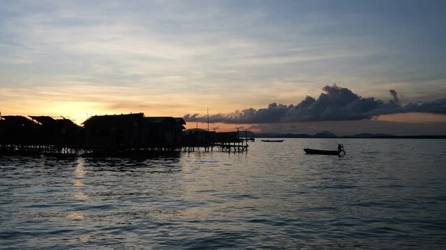 The traditional Bajau stilt house at Pulau Omadal, Semporna, Malaysia during sunset time with silhouette of the houses. The Bajau are a seafaring population in Southeast Asia