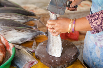 Cut tuna fish on the table of a fish seller in the fish market. The seller cut tuna into pieces.