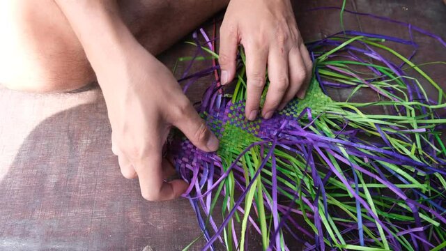 Bajau people weaving a traditional mat with a pandan straw leaves at Sabah.