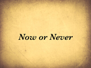 Now or never written on a paper background