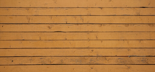 Naklejka premium Vintage wood background. Old weathered wooden plank painted in yellow color. Boards with cracked and peeling paint. Old painted wood wall - texture or background.