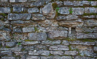 Old brown stone wall. Stone wall texture. Old rocks blocks in medieval wall. Exterior historical building. Village rural background. Graphic texture element.