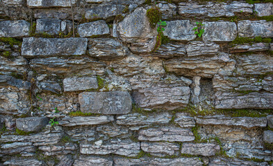 Old brown stone wall. Stone wall texture. Old rocks blocks in medieval wall. Exterior historical building. Village rural background. Graphic texture element.