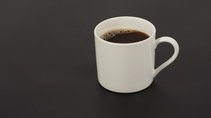 Hot coffee in white mug isolated on black background.
