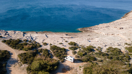 Fototapeta na wymiar White camper, rv, motorhome standing at a beach camp spot, Vis Island, Croatia