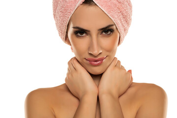 Young beautiful woman posing with a towel on her head on white