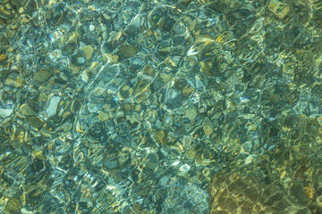 Fototapeta na wymiar Beautiful blue and yellow texture of color smooth stones with water is in the lake