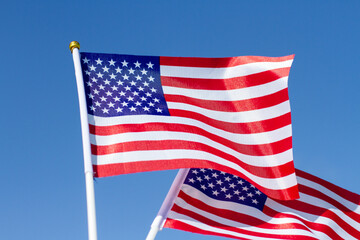 American Flag against the blue sky. Celebrating Independence Day of America. USA flag waving in blue sky.