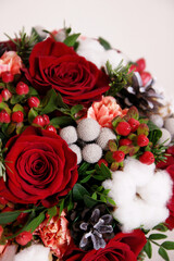 Fototapeta na wymiar Bouquet with red roses, cotton balls, cones, spruce and other flowers. Circle flowers bunch. Close up