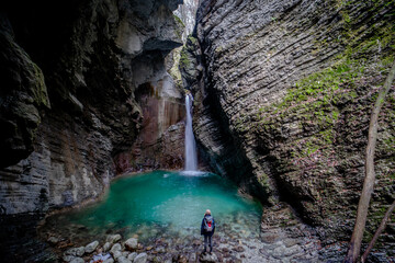 Person, backpacker standing in front of waterfall Kozjak in Triglav National Park, Slovenia