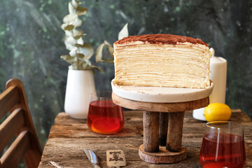 Tiramisu Crepe Cake, no decor on a wooden table. Side View.