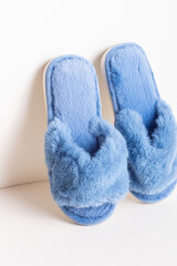 Blue women's home slippers on light background. Comfortable shoes for home