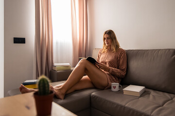 woman with blonde hair reading calmly by the window
