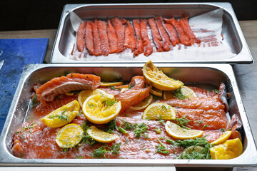 Salted and sliced pink fresh salmon, laid out on a baking sheet.