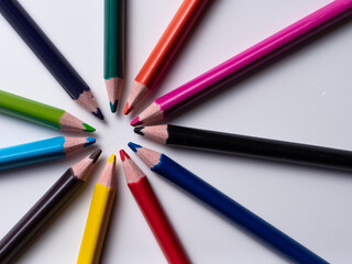 Fototapeta premium colored pencils forming a sun isolated on a white background, geometric shapes on a white background