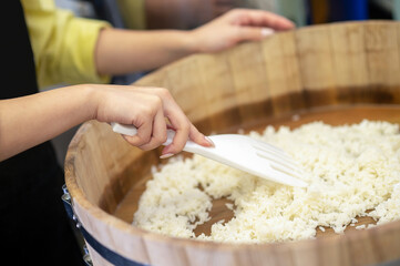 Woman preparing rice for sushi in the restaurants kitchen