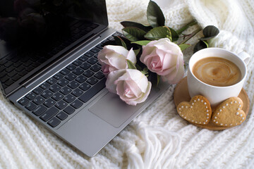 laptop, cup of coffee, bouquet of pink roses, heart shaped cookies. romantic background, valentine's day card. congratulations on March 8. cozy scene. with love.