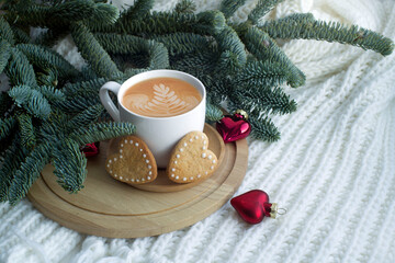 fir branches, a cup of coffee, cookies, red glass hearts. congratulations on valentine's day, march 8, gift to mom, romantic background.