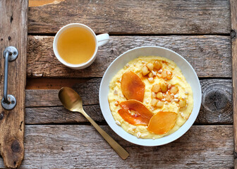 plate of sweet polenta with milk and caramelized pears, nuts.