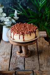 Cake pigeon's milk. Sponge cake and tender soufflé, creamy mousse. Garnished with milk chocolate and peanut. Side view, wooden background and coffee.