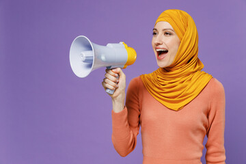 Fun promoter young arabian asian muslim woman in abaya hijab yellow clothes hold scream in...