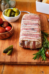 Terrine with pistachios and olives. Side view. Tomatoes, pickles, rosemary.