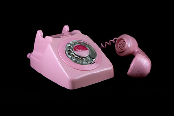 Vintage Pink Telephone on a Black Background