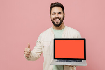 Young happy man 20s in jacket shirt hold use work on laptop pc computer with blank screen workspace...