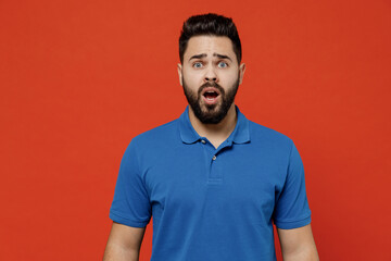 Young disappointed sad displeased unhappy caucasian man 20s wearing basic blue t-shirt looking camera with opened mouth isolated on plain orange background studio portrait. People lifestyle concept.