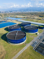 Drone view of sewage treatment plants, filtration of dirty or waste water. Stage of primary deposition, wastewater passes through large round tanks with mechanically driven scrapers.Vertical photo