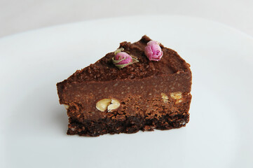 Slice of vegan chocolate nut cake on white plate close-up