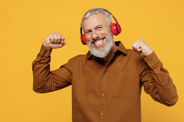 Vivid excited elderly gray-haired bearded man 40s years old wears brown shirt red headphones doing...