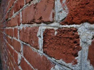 blurred brick wall perspective in detail, textured brickwork from close up angle view, rough red...