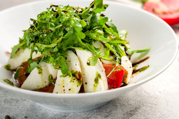 Caprese salad with mozzarella and tomato and aragula macro close up