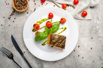 Salmon steak on the grill on white plate on grey concrete table top view