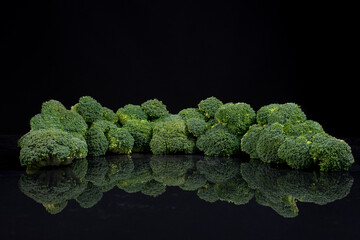 Floretes de brócoli fresco. Con reflejo de espejo en el agua. Paisaje hecho con comida sobre fondo...
