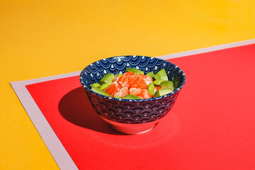 Poke bowl with rice, avocado, edamame beans and smoked salmon. Hard light, deep shadow