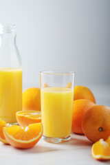 Naklejka na ściany i meble Oranges and orange juice in glasses 